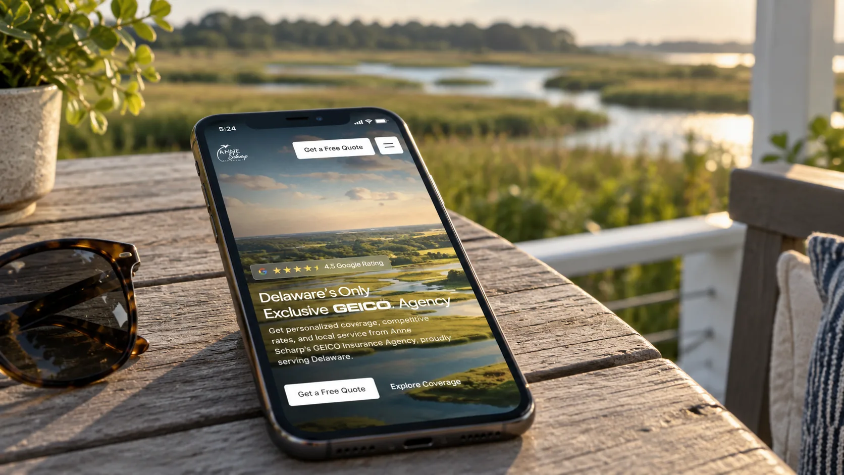 Anne Scharp Insurance homepage shown on a phone beside a marsh